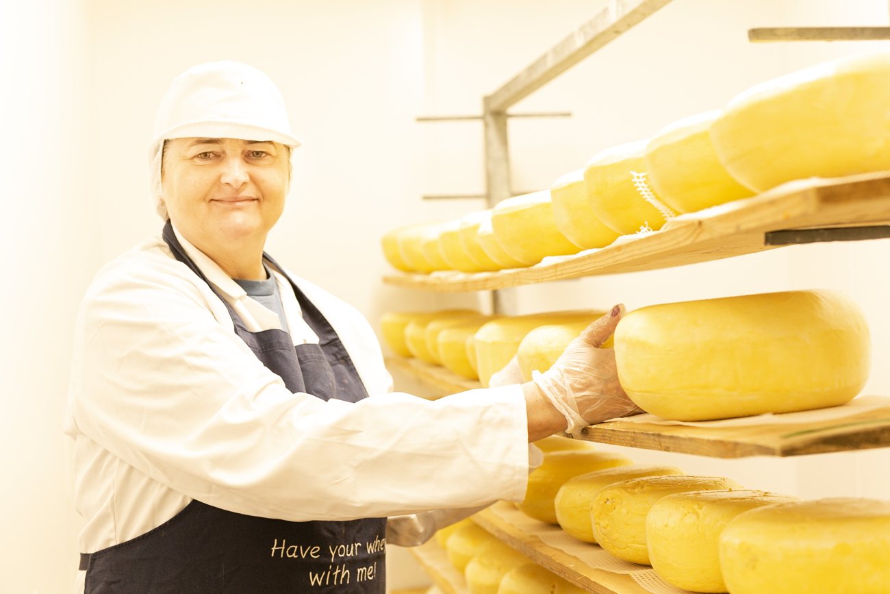A St Tola cheesemaker with maturing cheese on the racks
