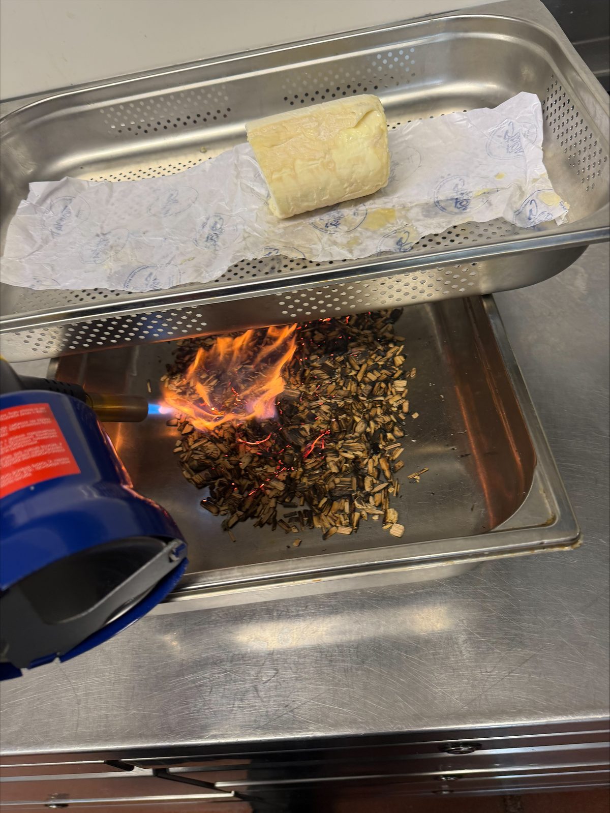 Lighting the hickory chips with a blowtorch beneath the St Tola log